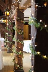 The Pillar Uprights At The Tithe Barn In Great Fosters Decorated With Ivy And Fairy Light Winter Wedding Decorations Winter Wedding Table Wedding Centerpieces