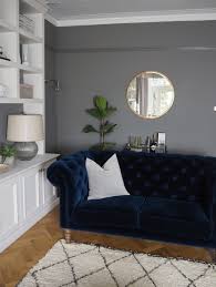 Festive living room with rich navy walls as a backdrop to rust coloured furniture pieces. Our Living Room Adding The Final Touches With West Elm The Green Eyed Girl
