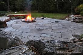 The backyard features an irregular bluestone stoop, seatwall, fire pit and a reclaimed chicago street paver patio with a bluestone inlay. Natural Flagstone Patio Fire Pit Indian Run Landscaping