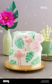 Two Tiered Tropical Wedding Cake With Fondant Tropical Wafer Paper Leaves And Flamingos With Ranunculus Flowers On Golden Cale Platter Stock Photo Alamy