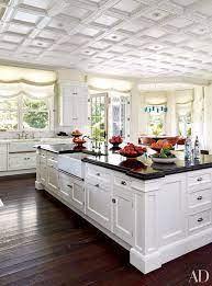Light brown wood floor with a white farmhouse sink, shaker cabinets, black granite countertops, beige black mixed cement 6″x6″ backsplash, an island and black countertops. 25 Black Countertops To Inspire Your Kitchen Renovation Architectural Digest