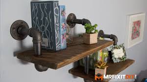 The frame is made of bare metal pipes with a black finish and the shelves are made of stained wood. Diy Industrial Pipe Shelf Youtube