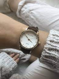 Il s'agit d'une montre boîtier rond en acier inoxydable et cadran blanc laissant apparaître la magnifique structure interne de la montre. Montre Femme Doree Cadran Stries Avec Strass Bracelet Simili Cuir Marron