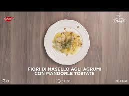 Il nasello in padella è un secondo piatto leggero e ricco di proteine, insaporito da olive taggiasche, succo di limone e pomodori secchi. Fiori Di Nasello Agli Agrumi Con Mandorle Tostate Youtube