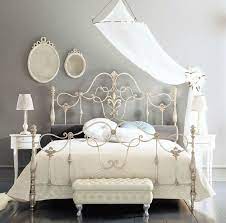 Use an iron console table or wrought iron foyer table to welcome guests in the entry and wrought iron sofa tables to display decorative objects, plants and candles, divide a large room, or hold lamps behind a sofa. Fancy Wrought Rod Iron Beds Curved With Silver Color And Wall Mounted Mirror Also Small White Table And White Iron Beds Iron Bed Frame Wrought Iron Bed Frames