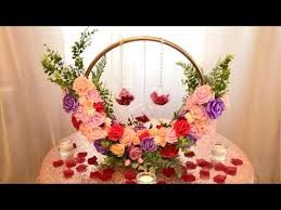 The basics that you need are a dollar store hula hoop, spray paint, flowers, and ribbon. How To Make A Hoop Floral Centerpiece