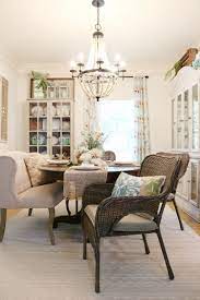 Wood beams and trim, a farmhouse style table and industrial bronze light fixtures bring rustic charm, while the vibrant pops of color from the turquoise chairs add a modern flair. Affordable Dining Room Decor For That Casual Cottage Farmhouse Look