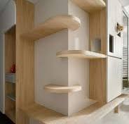 The image shows a modern and minimalist indoor cat climbing ...
