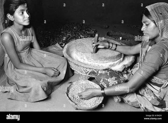 Two women grinding flour in Black and White Stock Photos & Images - Alamy
