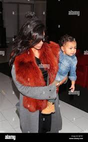 Kim Kardashian And Baby Daughter North West Arrive At Los Angeles International Airport Kim Wearing Sunglasses And A Fur Collared Coat Featuring Kim Kardashian North West Where Los Angeles California United States When