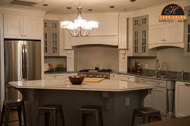 A large kitchen with a rustic details to it boasts a large kitchen island with a granite countertop lighted by four beautiful pendant lights. Kitchen Island Design Tips Harrisburg Kitchen Bath