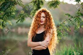 Portrait of beautiful redhead woman with wavy hair and green eyes looking at camera. Portrait Af A Beautiful Redhead Woman Outdoors Stylish Romantic Stock Photo Picture And Royalty Free Image Image 132657435