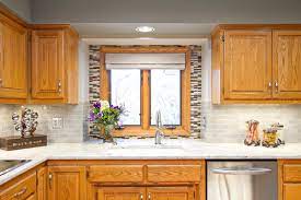 Honey oak kitchen cabinets with granite countertops in beige or tan granite, which is colored with swirls of gray, black and dark brown. Granite Colors That Will Match With Oak Cabinets Perfectly