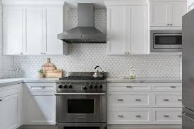 All White Kitchen With White Shaker Cabinets Displays Chrome Hardware Flanking A Sta Arabesque Tile Kitchen Arabesque Tile Backsplash Kitchen All White Kitchen