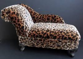 Seat measures 19h in crafted with a wood frame legs in an espresso finish includes one (1) matching accent pillow pewter nailhead accents upholstered in cheetah print fabric curved back and body for comfortable seating some assembly. Leopard Chaise Lounge