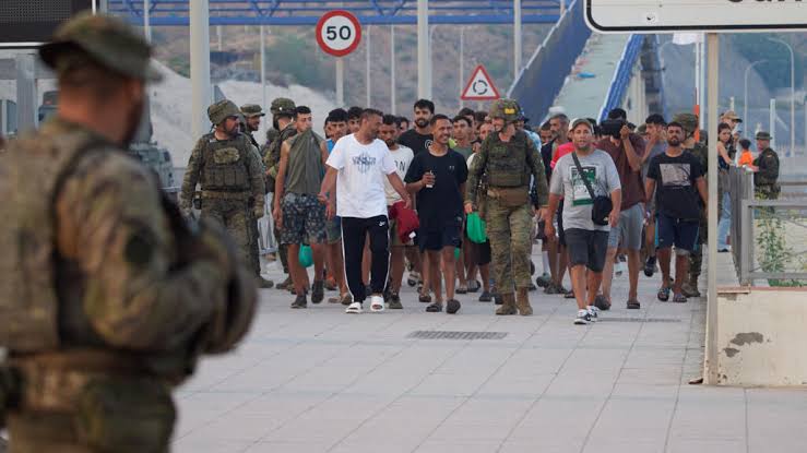 Spanish border security officers conducting identity checks at a checkpoint following new government directives.