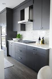 Instead of toning down your oak cabinets, highlight their beauty and elegance with a sleek, dark countertop. Dark Gray Flat Front Kitchen Cabinets With Gray Mosaic Tile Backsplash Modern Kitchen