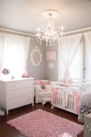 Contemporary pink and gray nursery boasts side by side gray cribs placed on a yellow red and gray rug in front of windows accented with white curtains finished with a pink and blue stars border. Gallery Roundup Pink And Gray Nurseries Project Nursery