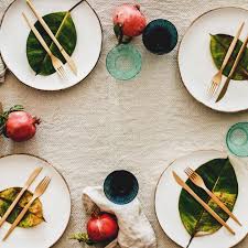 At a formal table, the service plate decorates the cover and the rim should frame the appetizer plate with a surround of no less than one inch. Fresh Table Setting On Brown Table Cloth Leaves On Bright Plates Fruit Glassware Square Crop Noun Project