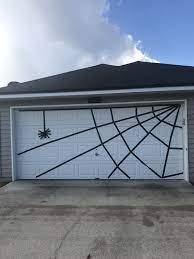 Halloween Garage Door Spider Web Using 2 Inch Black Painters Tape Dollar Tree Spider Halloween Garage Garage Door Halloween Decor Halloween Garage Door