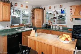 Green cottage kitchen features a brown french freestanding center island illuminated with basket chandeliers. What To Do With A Kitchen With Wood Cabinets And Green Countertops Hometalk