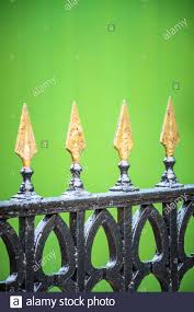 La balivo è la vera star. Punte Dipinte In Oro Su Un Cancello In Ferro Battuto Nero Con Fondo Verde Foto Stock Alamy