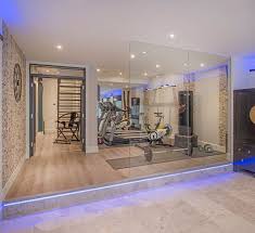 A basement renovation complete with a custom home theater, gym, seating area, full bar, and showcase wine cellar. Home Gym Designs That Will Make You Wanna Sweat Gym Room At Home Home Gym Basement Home Gym Decor