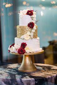 Gold White Tiered Wedding Cake With Burgundy Red Florals Wedding Cake Red White And Gold Wedding Cake Wedding Cake Table