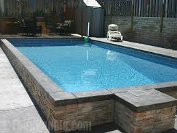 Faux Stone Veneer Wraps This Pool Giving It A Sophisticated Professional Appearance Pool Landscaping Stone Around Pool Faux Stone Panels