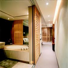 This metal grille serves as a tv feature wall, while separating the living room area from the foyer. Room Dividers Shutter Divider Shutters American Shutters
