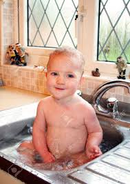 child bath in kitchen sink. baby splash