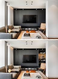 Scandinavian modern living room with cool neutral color scheme that consist of white walls, chandelier, a glass table, flowers decoration and wooden floor. Metallic And Black Accents Help Give This Apartment A Glamorous Interior