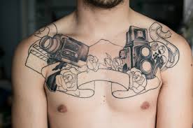 Red roses make up one of the most attractive chest tattoo ideas. Two Movie Camera With Ribbon And Roses Tattoo On Man Chest