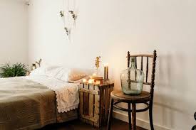 Minimalist Style Home Bedroom Interior Design With Cozy Bed And Wooden Furniture Placed Near White Wall With Boho Decorations Stockphoto