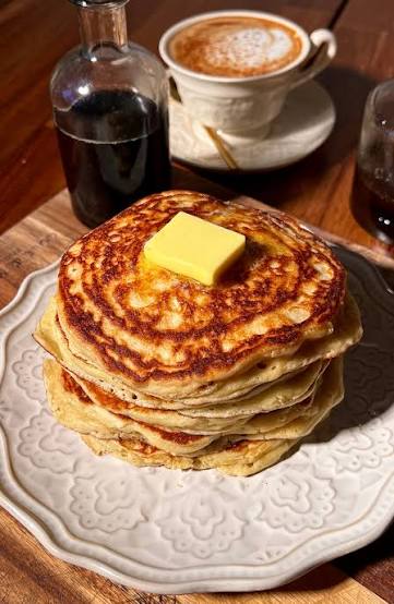 Classic Buttermilk Pancakes stacked high with butter and maple syrup