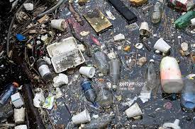 assorted trash covers waterfront at city line waterfront city stock photos