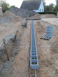 0,50 m mauer aus betonschalungssteinen mit bewährung auf einem frostsicheren fundament aus gegossenem beton mit metallkörben verstärkt, errichten. Die Ersten Schalungssteine Sind Gesetzt Concrete Block Walls Dry Stone Wall Retaining Wall