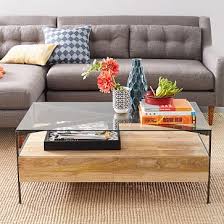 The elegant, classy coffee table with a glass top and handy drawers perfectly matches the similar other furniture and the cream carpet. Glass Topped Industrial Storage Coffee Table
