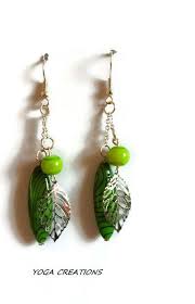 Boucles D Oreilles En Perle De Verre Verte Perle Olive Plate Verte Et Traits Noirs Et Breloque Feuille En Metal Argente Bijoux Boucles Createur De Bijoux