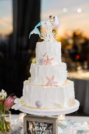 Eating dinner on the beach is not a simple undertaking. Beach Themed Wedding Cake With Mermaid Cake Topper