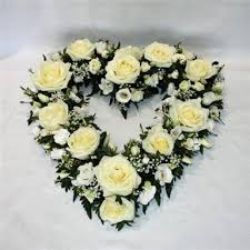 Gathered flowers and foliage, gently tied with a simple raffia bow. White Open Heart Funeral Flowers Aylesbury