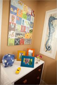 A gray boys nursery design completed with a distressed alphabet carved dresser showcasing decor and a rope table lamp. Alphabet Inspired Nursery