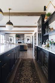 Farmhouse Black Cabinet Kitchen With Vintage Runner And Beams More Source On Home Bunch B Modern Farmhouse Kitchens Interior Design Kitchen Home Decor Kitchen
