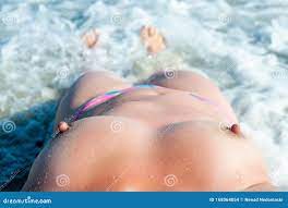 Topless Woman Lies on a Sandy Beach by the Sea. Naked Woman Enjoys  Sunbathing. Bare Breasts of a Beautiful Woman. Stock Photo - Image of  charming, leisure: 168064854