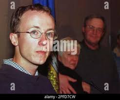 Mitchell Keiver, left, answers questions at a news conference as his  parents Sandra and Glen Keiver embrace at the Calgary Airport in Alberta,  Sunday night, March 7, 1999. Keiver, who escaped the slaughter of eight  foreign tourists in Uganda last week ...