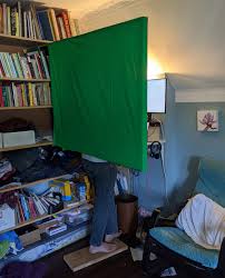 Make a frame out of pvc that is slightly bigger, i.e. Setting Up A Green Screen