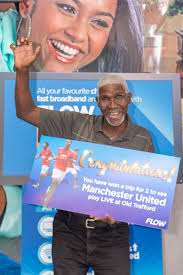 Ashton Wharwood receives his prize from Ria Maharaj, Senior Product Manager  at Flow. Ashton signed up for a Flow bundle during our Christmas promotion  and won an all inclusive trip for two