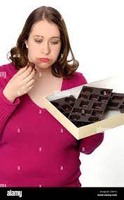 Humorous Photo Of A Woman Who Has Eaten A Large Box Of Chocolates And Is Feeling Sick And Bloated Stock Photo Alamy
