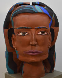 Silvija Singh uses their work “Person of Interests: Woman of Colors” to  address the topic of police stereotyping in “ISMS: Narratives, Issues, and  Difficult Topics of Our Time” “A monument-sized head of