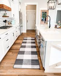 The black and white kitchen is a classic that is never 'out of style', making it a perfect choice for those who are not too keen on constantly changing the but designing and decorating a black and white kitchen is not as easy as just putting stuff in both these hues together. Linear Aztec Black Rug White Farmhouse Kitchens White Kitchen Rugs White Kitchen Decor